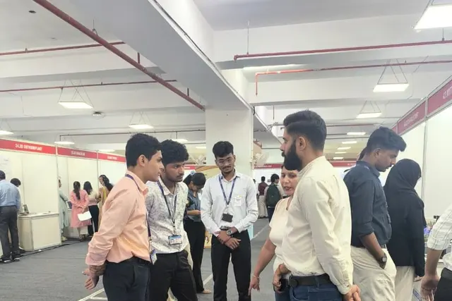 Visitors gathered around the blue sensor mat while a founder explains the system.